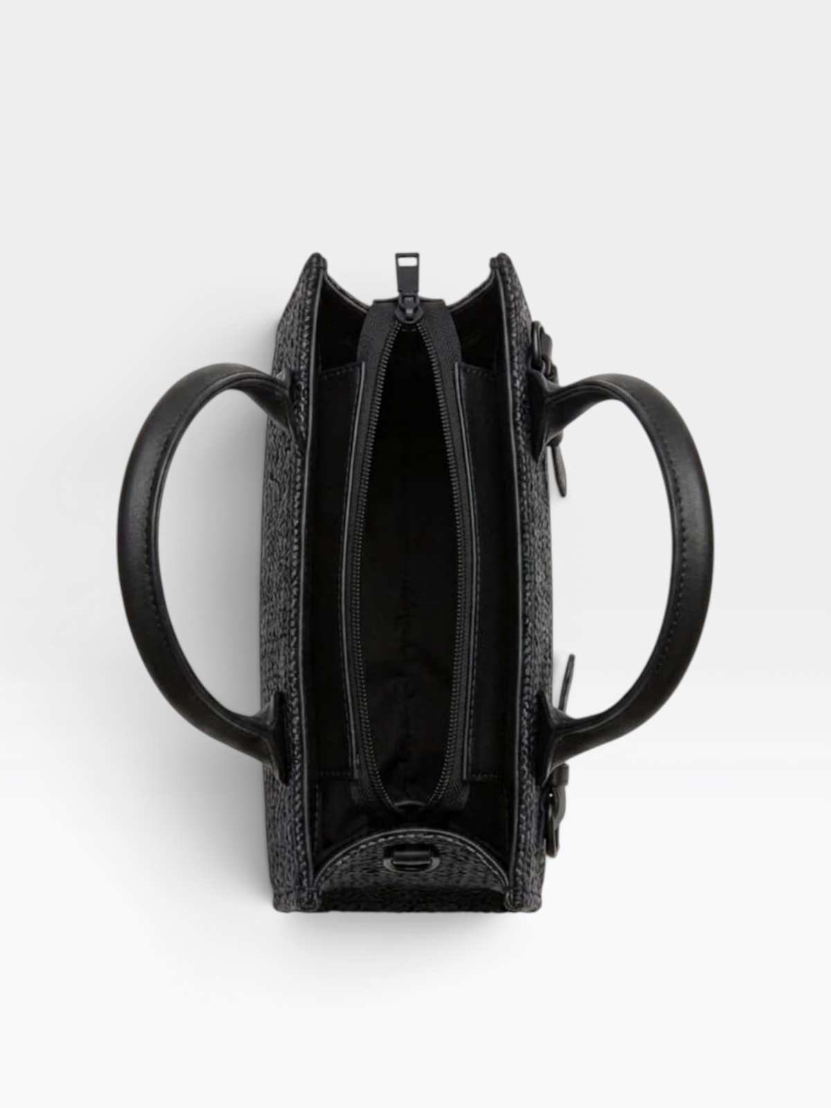 Top-down view of a black textured handbag with two circular handles and an open zippered interior, shown on a light gray background.