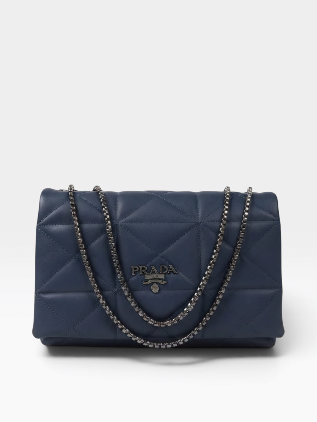 A navy blue Prada quilted leather shoulder bag with a silver-tone chain strap and a central metal logo plaque.