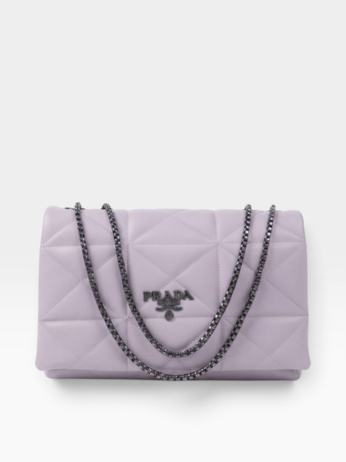 A light purple Prada quilted shoulder bag with a silver-tone chain strap and a silver-tone metal logo plaque on the front.