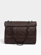 A dark brown quilted leather handbag with a flap top and a black chain strap, photographed against a light gray studio background.