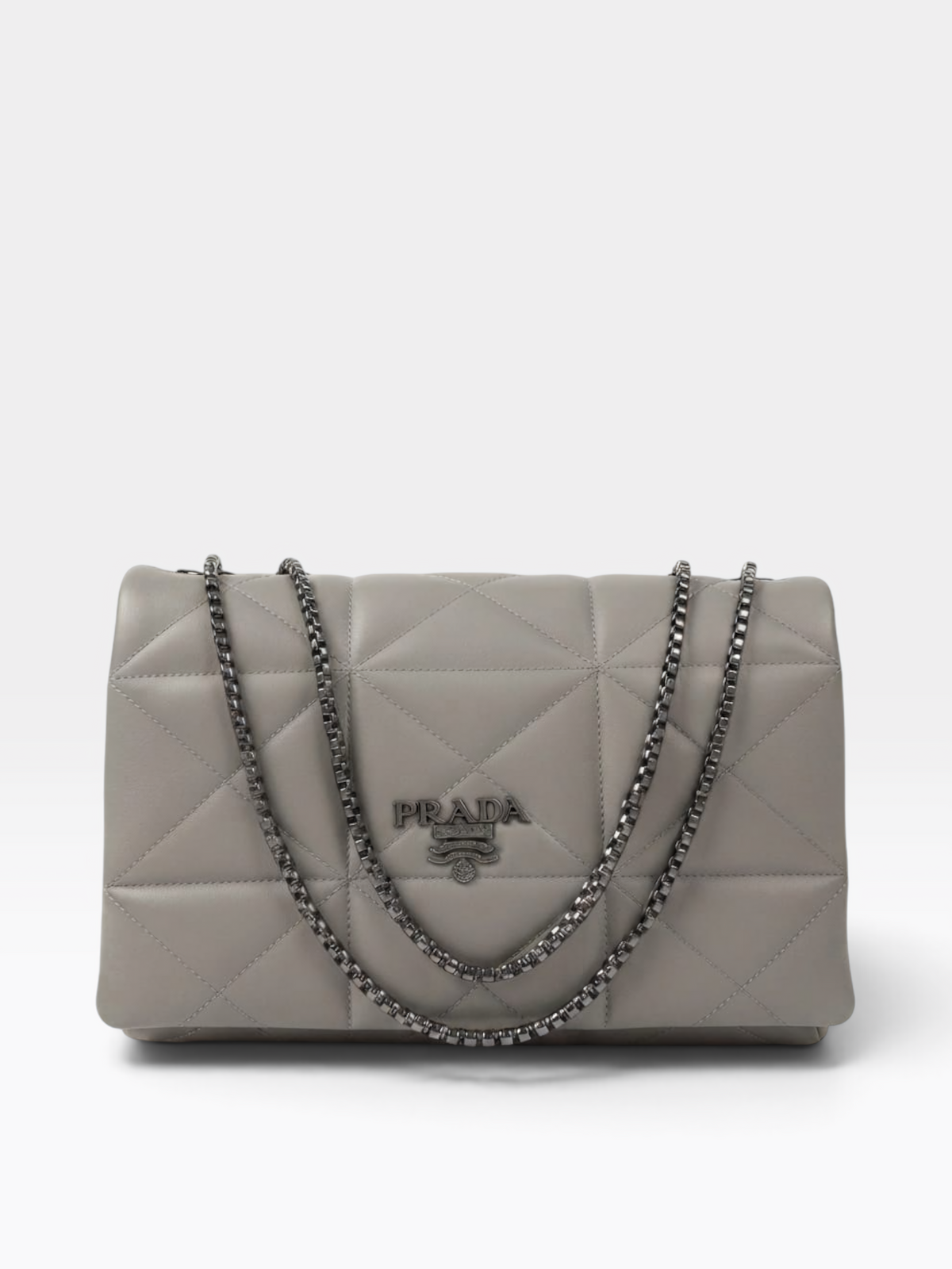 A Prada quilted shoulder bag in light gray leather with a silver-tone chain strap and a central Prada logo plaque, photographed against a clean white background.
