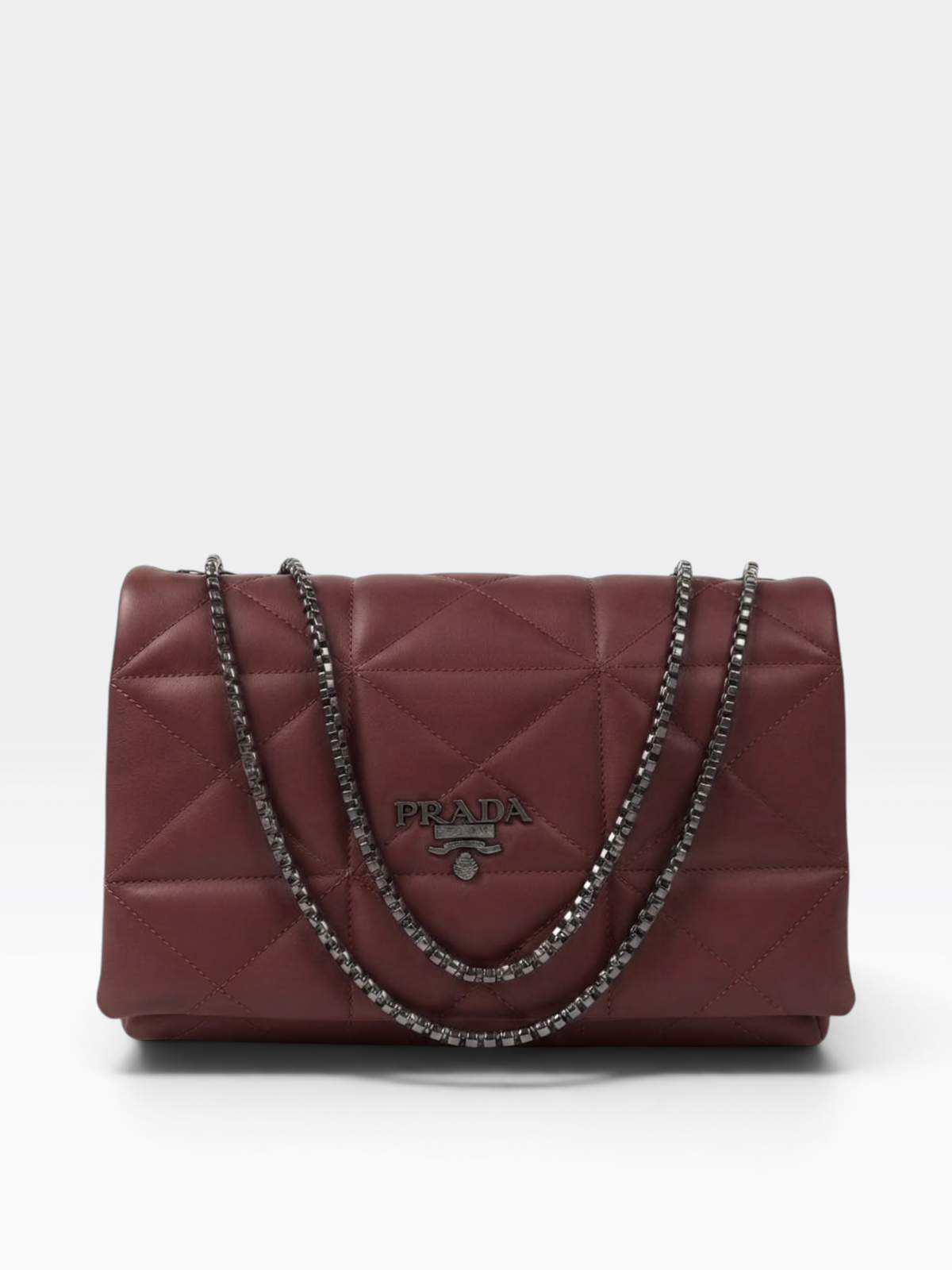 A Prada quilted leather shoulder bag in burgundy red, featuring a diamond-quilted pattern, a silver-tone chain strap, and a silver-tone metal Prada logo plaque on the front.